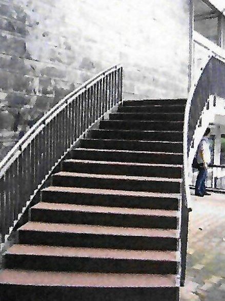 Geschwungene Außentreppe mit rotem Quarzbelag